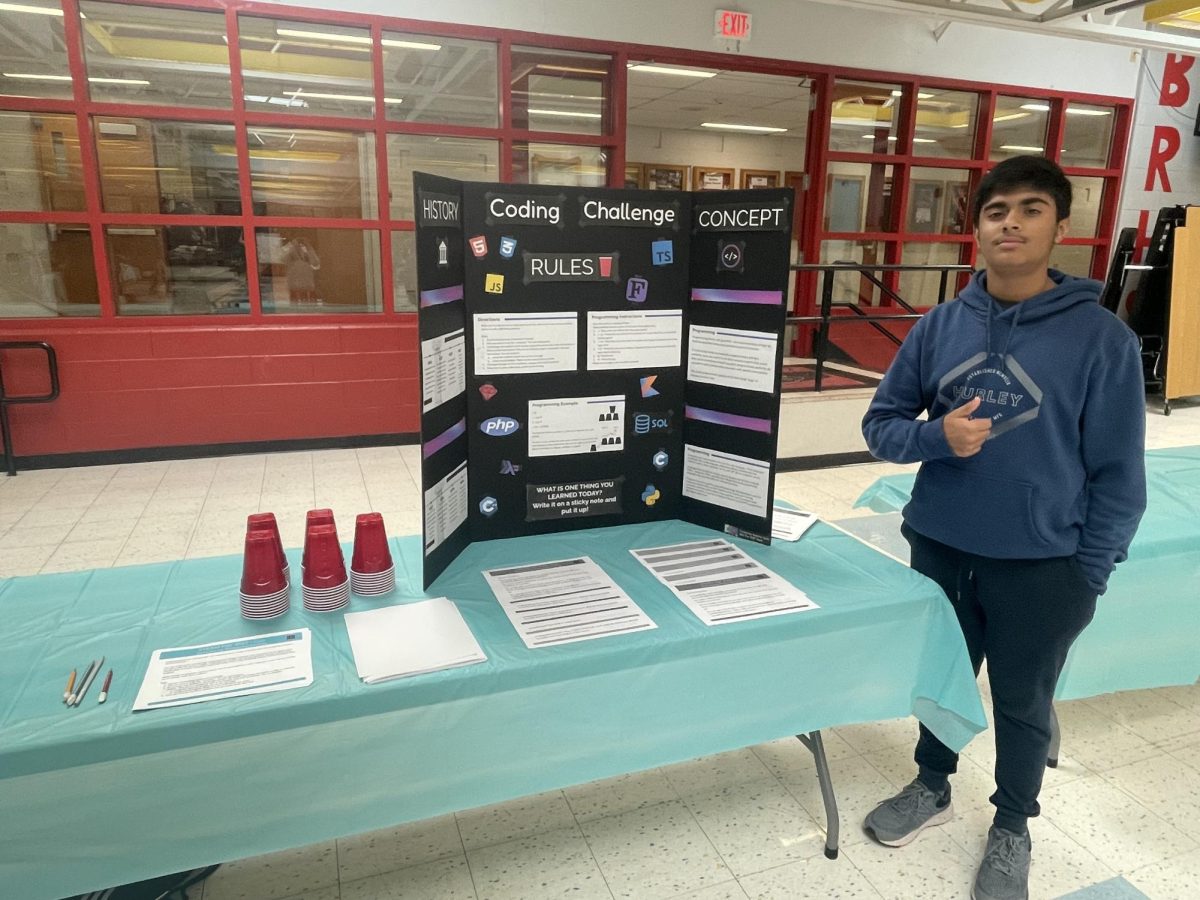 BRHS student Kush Dave stands next to his programming-related presentation. 
