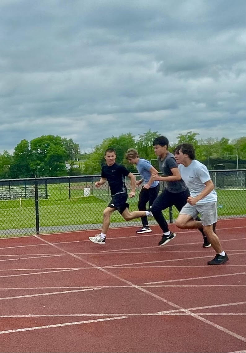 Members of the boys track and field team run at practice.