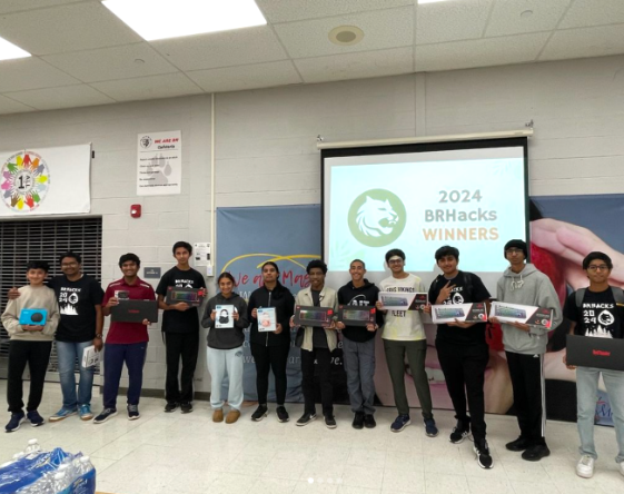 The winners of the hackathon pose for a group picture with their prizes.