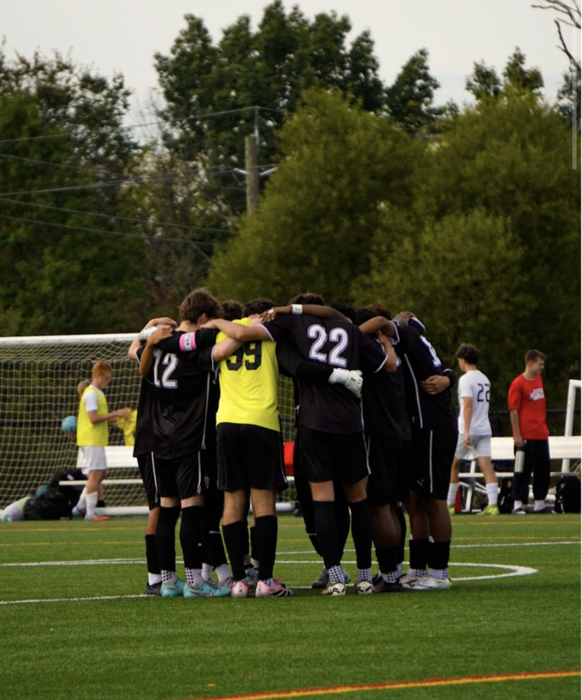 Boys Varsity soccer team huddles up for strategy and support